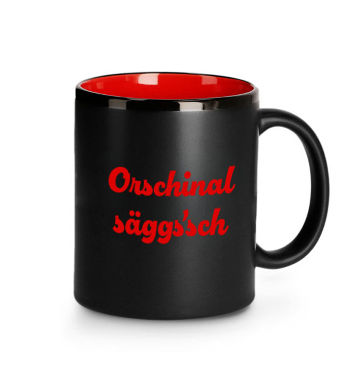 Schwarze Jubiläums-Tasse mit roter Innenglasur und Schriftzug „Orschinal säggs'sch" zum 500. Jubiläum von Auerbachs Keller in Leipzig.